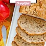 A loaf of apple bread and two apples.