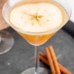 Caramel apple martini and cinnamon sticks on a serving tray.