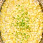 Cheesy creamed corn in an oval skillet.