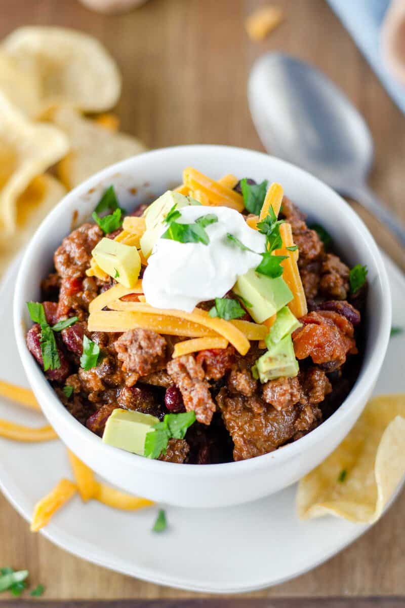 Chili garnished with avocado, cheese, and sour cream.