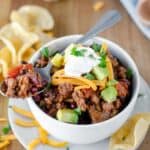 Chili on a spoon on top of a bowl of chili.
