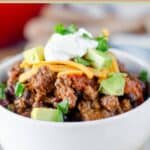 A bowl of chili with various toppings.