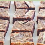 Several chocolate cream cheese brownies on a baking sheet.
