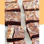Cream cheese marbled brownies on parchment paper.