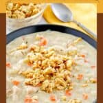 A bowl of creamy turkey soup topped with crumbled stuffing.