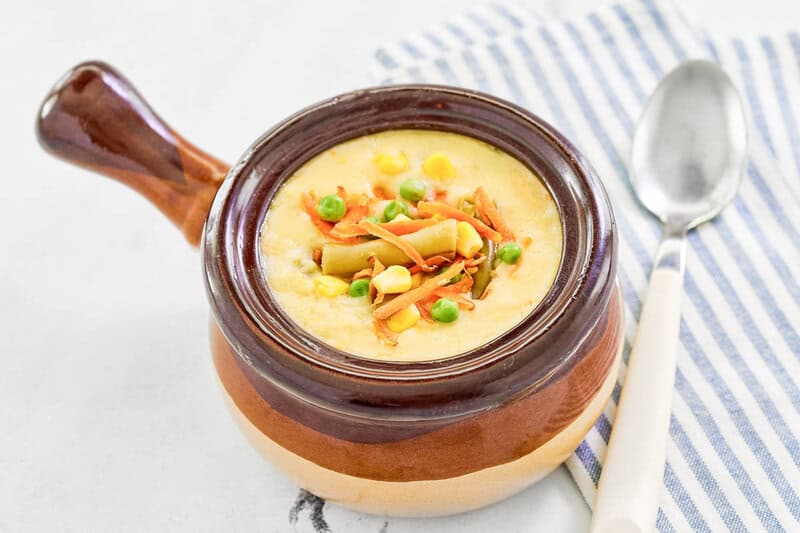 Copycat Dolly Parton Dixie Stampede creamy vegetable soup garnished with veggies.