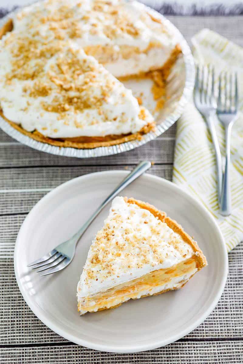 Double layer pumpkin pie and a slice on a plate next to it.