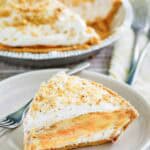 Double layer pumpkin pie and a slice on a plate in front of it.