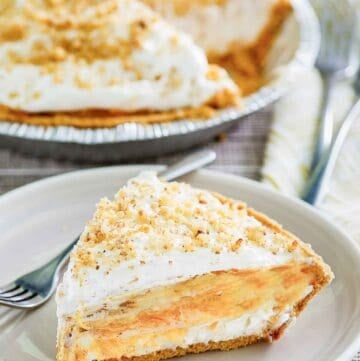 Double layer pumpkin pie and a slice on a plate in front of it.