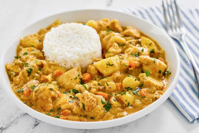 Instant Pot Thai yellow chicken curry and white rice served in a bowl.