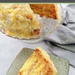 Mountain dew cake with coconut pineapple icing on a cake stand and a slice on a plate.