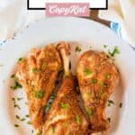Roasted turkey legs on a plate and a kitchen towel.