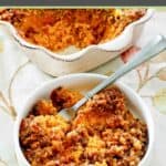 Sweet potato casserole with pecans and a fork in a bowl.