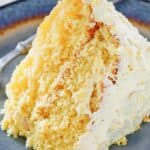 A slice of ambrosia cake with pineapple frosting.