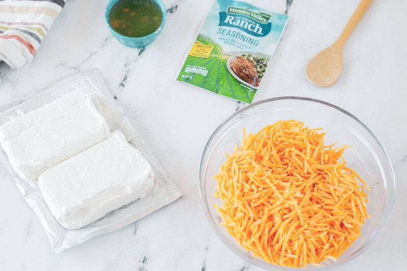 Cold beer cheese dip ingredients on a marble surface.