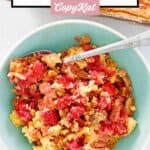 Cherry pineapple dump cake and a spoon in a small bowl.