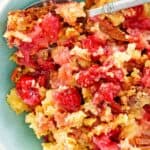 Cherry pineapple dump cake and a spoon in a bowl.