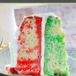 2 layer jello poke cake with cool whip frosting slice on a plate.
