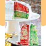 Red and green jello poke cake on a cake stand and a slice on a plate.