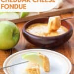 Apple slices and bread pieces dipped in homemade Melting Pot cheddar cheese fondue.