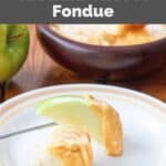 Homemade Melting Pot cheddar cheese fondue on a bread cube and apple slice.