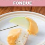 Homemade Melting Pot cheddar cheese fondue on an apple slice and bread cube.