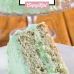 Pistachio cake slice on a plate in front of the cake.
