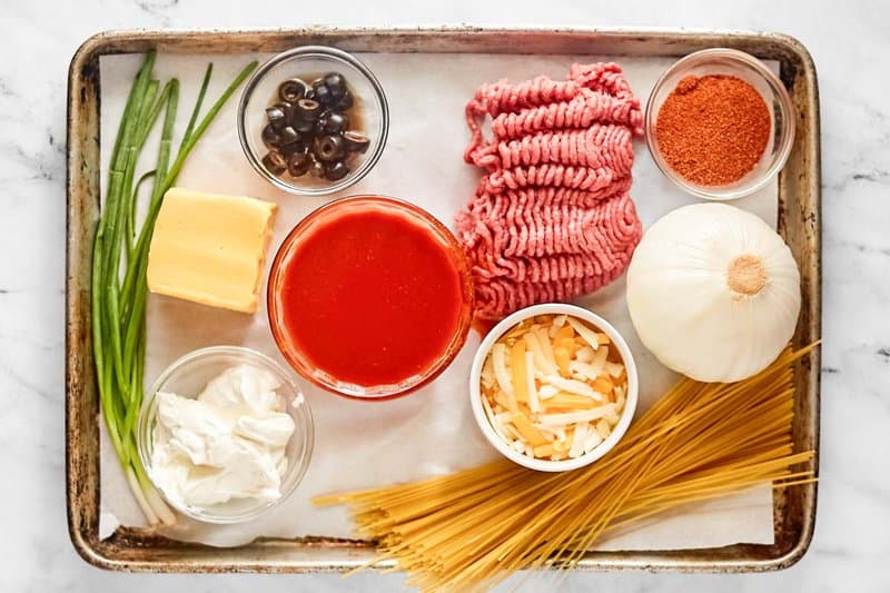 Taco spaghetti casserole ingredients on a tray.