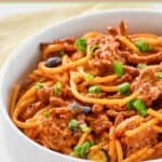 A bowl of cheesy taco spaghetti casserole.