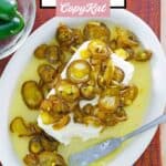 Candied jalapenos served over cream cheese on an oval platter.