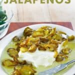 Candied jalapenos over cream cheese on a platter.
