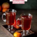 Two mugs of homemade wassail on a small wood serving tray.