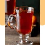 Homemade wassail in a glass mug.