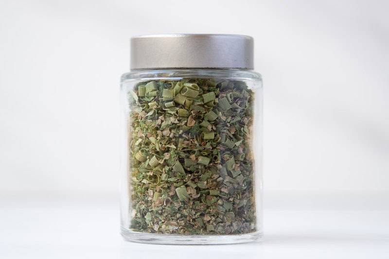 Homemade fine herbs blend in a small glass jar.
