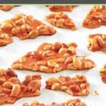 Pieces of microwave peanut brittle candy on parchment paper.