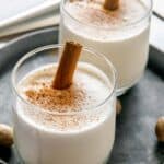 A glass of milk punch with a cinnamon stick.