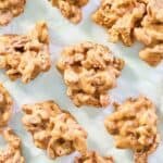 Homemade pecan pralines scattered on parchment paper.