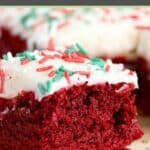 A red velvet brownie with cream cheese frosting and sprinkles on a spatula.