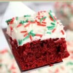 Red velvet brownie with cream cheese frosting and sprinkles on a spatula.