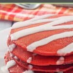 Four red velvet pancakes in a stack on a plate.