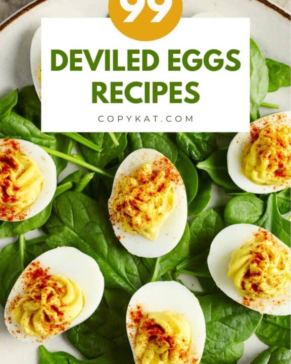 Deviled eggs on top of spinach leaves on a plate.