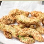 Crispy air fryer avocado fries on parchment paper.