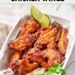 Air fryer sweet and spicy wings in a serving dish lined with parchment paper.