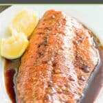 Baked salmon with sauce on a platter.