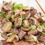 Homemade Benihana hibachi steak with mushrooms garnished with green onions.