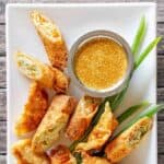 Homemade Benihana magic mustard sauce and egg rolls on a square plate.