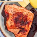 Homemade Cheddars grilled salmon with bourbon glaze and two lemon wedges.