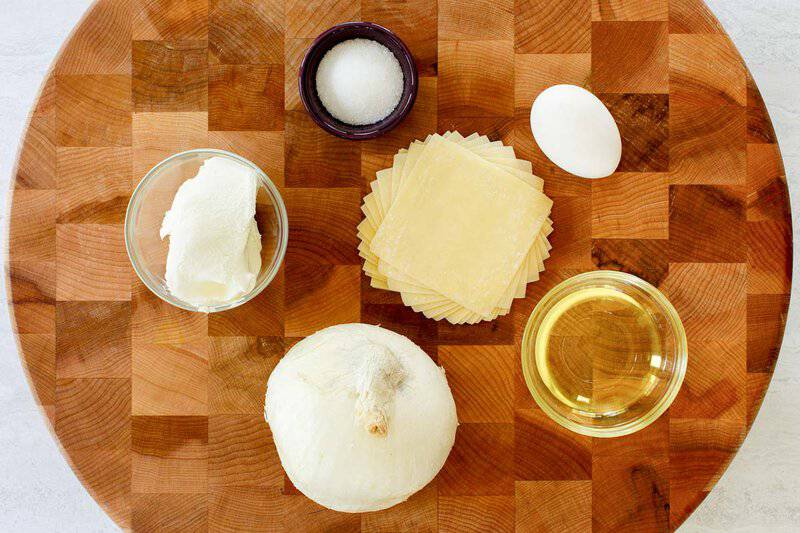 Cream cheese wontons ingredients on a round wood board.