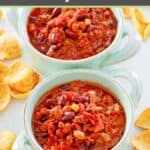 Crockpot chili in two bowls and Frito corn chips next to them.