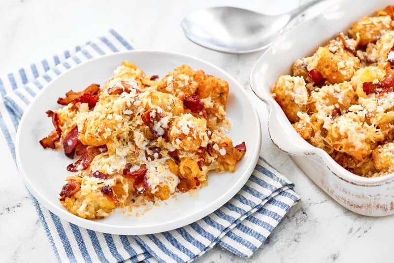 Copycat Domino's cheddar bacon loaded tater tots on a plate and in a serving dish.